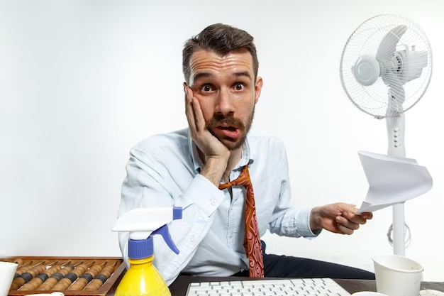 Young man suffering from the heat in the office