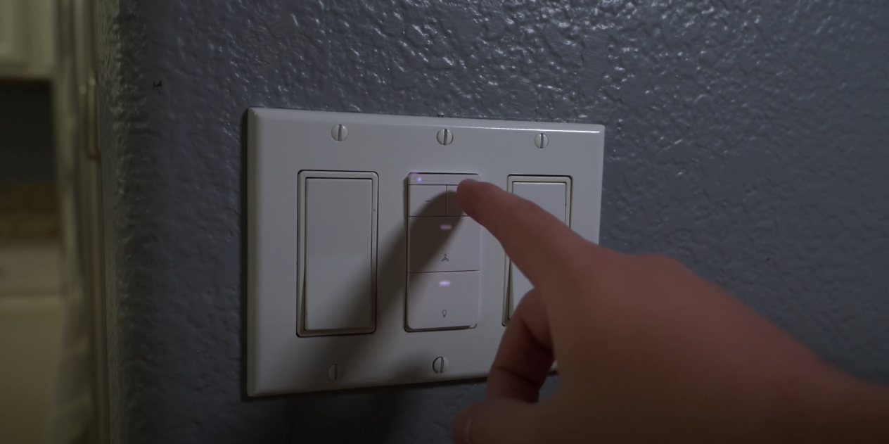 Hand pressing ceiling fan switch