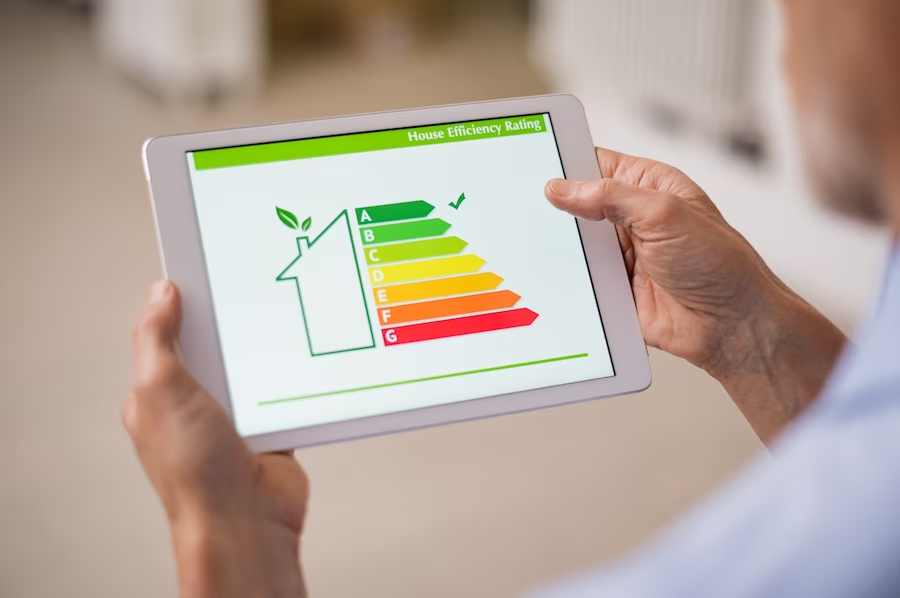 A hand holding a tablet displaying a home efficiency rating